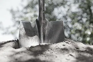 Spade nedstucken i en hög med sand